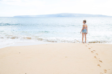 Teenage girl alone at tropical island ocean