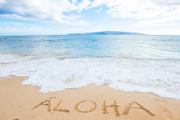 The word Aloha written in sand at the beach - obrazy, fototapety, plakaty