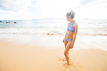 Teenage girl alone at tropical island ocean