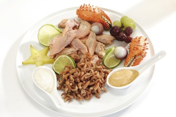 Fancy fish platter: smoked salmon filet, shrimps and crab pincers with fruits and dips