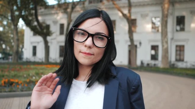 Portrait of young businesswoman disapproval gesture with hand: denial sign, no sign, negative gesture closes the camera with hand, professional female manager wearing glasses and suit, slow motion.