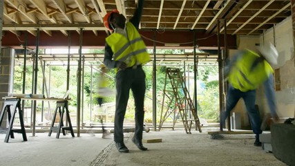 Time lapse of busy construction team working together on building site - Powered by Adobe