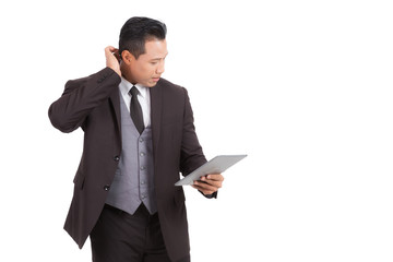 Businessman looking to tablet on isolated background.