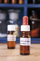 Homeopathic liquid remedy, Bach's flower remedy in bottles in front of an apothecary's cabinet