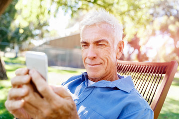 Obraz premium LoMature man outdoors using mobile phone