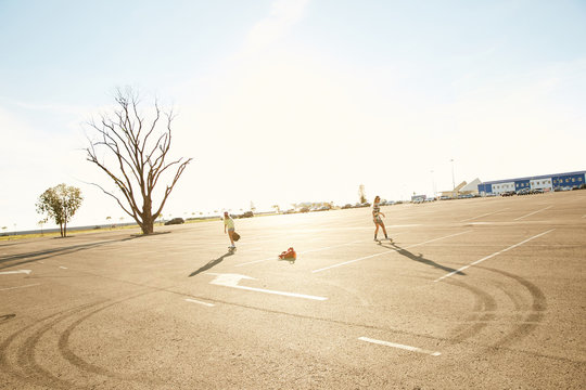 Girls skateboarding on a parking in the sunset in Sochi
