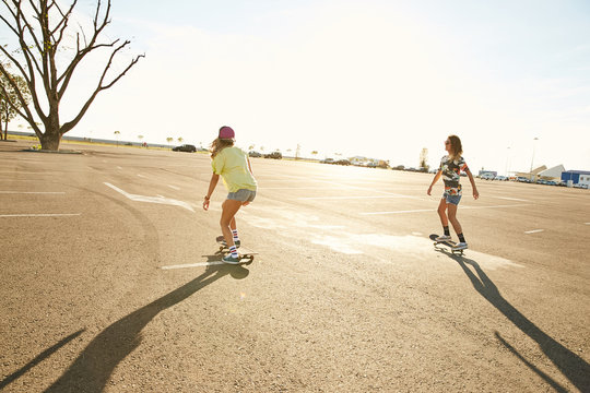 Girls skateboarding on a parking in the sunset in Sochi