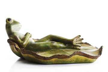 Frog figurine lying on a lily pad