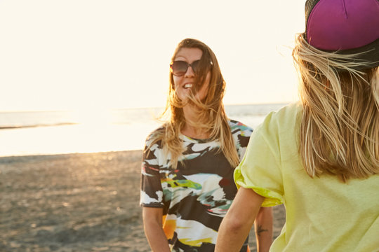 Girls having fun on the sea shore in sunset 