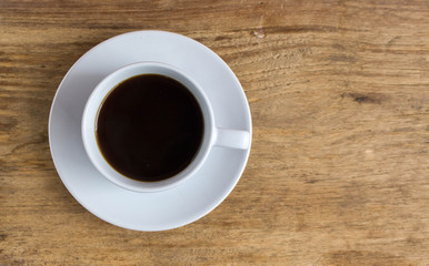 White cup of hot coffee on wooden table with copy space. Beginning the new working day in the morning with coffee. 
