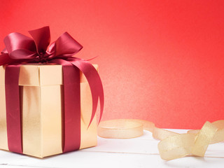 Valentine festival , New year Gold gift box with red ribbon. Red background for create idea copy space.