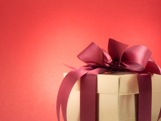 Valentine festival , New year Gold gift box with red ribbon. Red background for create idea copy space.