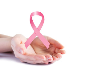 Pink ribbon on hands for breast cancer awareness on white background