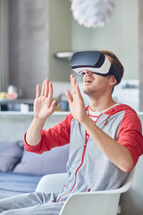 Curious man with vr goggles watching and touching imaginary objects