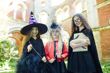 Smiling witches with halloween magic symbols gathered for having fun and playing tricks