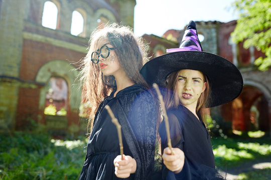 Cute witches in warlocks showing their magic wands and power
