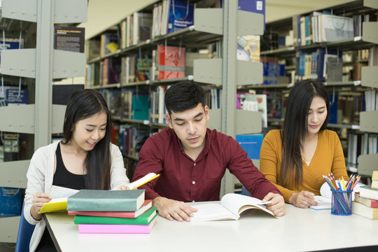 Group of Student reading books in the library with attractive smiling together . People with Education concept.
