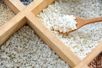Close up of fine stone or grit in wooden spoon for creating beautiful plant pot