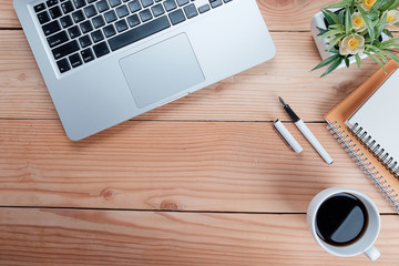 Office desk table with pen,keyboard ,smartphon,notebook, cup of coffee and flower. Top view with copy space (selective focus).