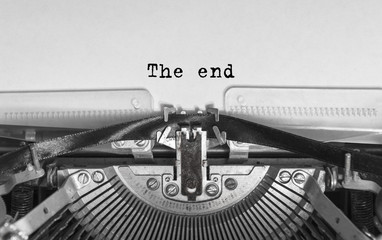 The end inscription in a vintage typewriter. Mechanisms close-up. Entering words into an old typewriter.