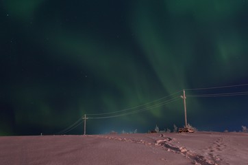 The snow covered the hills and in the sky the stars and the aurora borealis.