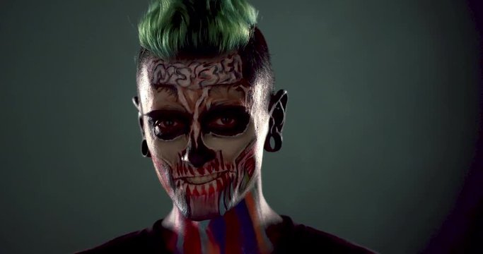 Close view of man with scary skeleton face. Halloween face art, zombie makeup on mans face.