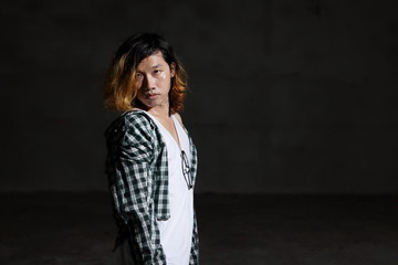 Portrait of androgynous beautiful young man as a beautiful woman in dark background.