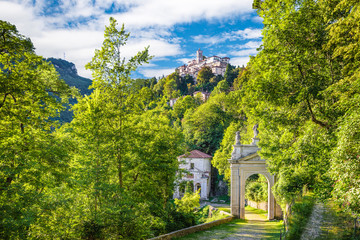 Sacro Monte of Varese (Santa Maria del Monte), Italy. Via Sacra that leads to medieval village (in the background), with the tenth chapel and the third arc. World Heritage Site - Unesco