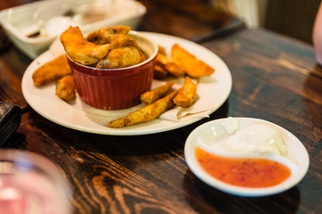 Fried potato with peel served in the red cup with mayonnaise and spicy sauce at the restaurant in Chiang Mai, Thailand.