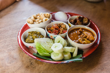 Khan tok is a pedestal tray used as a small dining table by the Lanna people (of northern Thailand). Include northern food and vegetables.