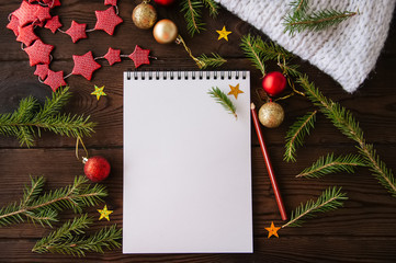 White empty notepad paper with christmas decoration on a wooden background. Flat lay.