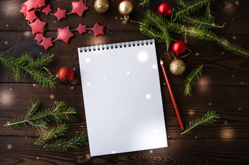 Obraz premium White empty notepad paper with christmas decoration on a wooden background. Flat lay.