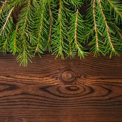 Christmas backdrop. Fir tree branches on a wooden background.
