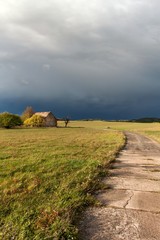 The dark sky before the storm. Old barn. Autumn evening with black clouds.