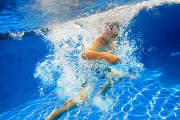 Child swims in swimming pool underwater
