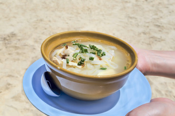 Thai chicken noodle soup on the beach - selective focus