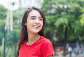 Attractive woman in a red shirt outdoor in a park