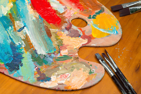 paintbrush and filled palette on wood table