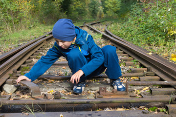 boy sitting on the railroad track