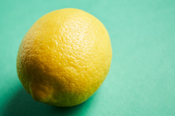 Juicy ripe lemon on a green background