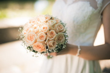 Bride is holding a bouquet of roses