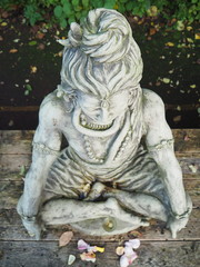 Fototapeta na wymiar Shiva Statue aus Stein sitzend auf Holzplattform aus Vogelperspektive