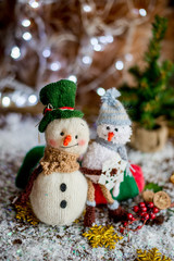 Handmade yarn snowman holding gifts in a sock, boot.