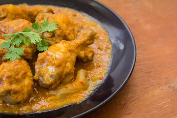 Massaman chicken placed on a wooden table Old brown.,spicy muslim curry muslim food spicy. Eaten with rice or roti