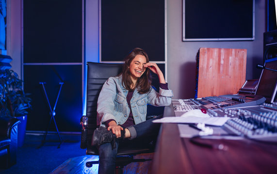 Smiling female sound technician in recording studio