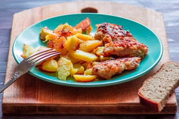 Homemade chicken nuggets with fried potatoes on a blue plate