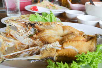 deep fried snapper fish with fish sauce on white dish