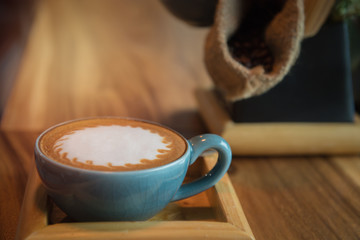 latte art coffee cup on wood table in coffee shop.