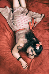 Pinup girl posing on a red bed