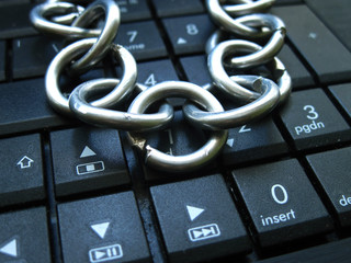 Chain with lock on computer keyboard. It means laptop banned or internet banned. Symbol of computer...